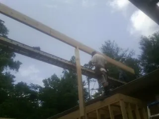 Carpenter setting a ridge beam over a new addition frame — Ice Dam Removal by Roofing Brothers in Casey