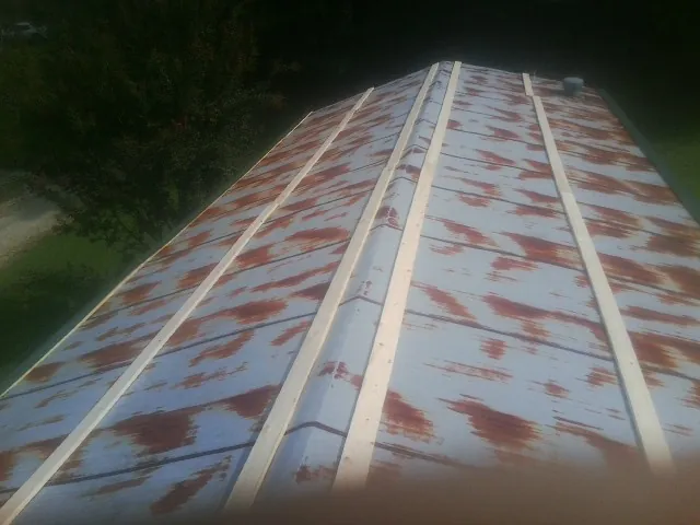 Rusted metal roof panels with new wood purlins before replacement — Storm Damage Roof Repair in Casey by Roofing Brothers