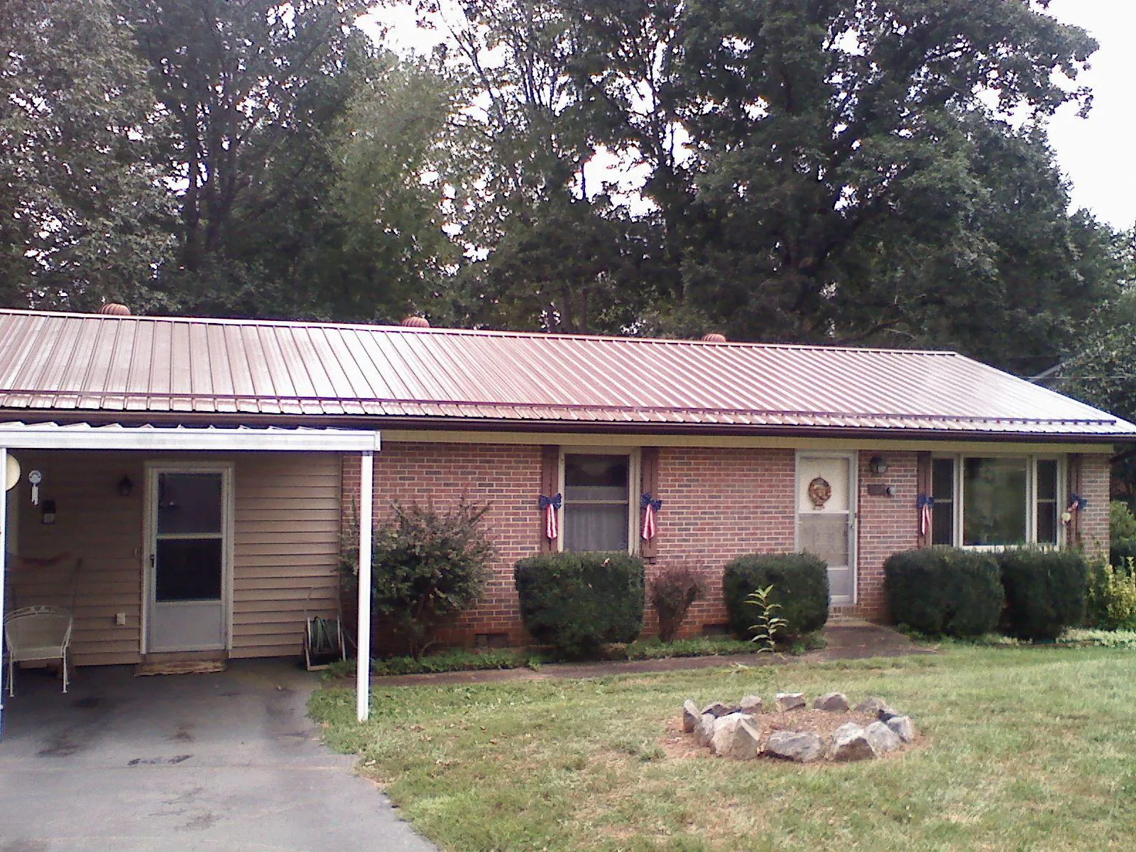 Bronze metal roof and carport on a brick ranch home — Roof Repair work by our crew in Casey